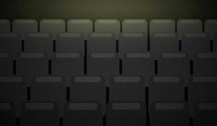 Empty rows of tiered seating in a darkened concert venue.
